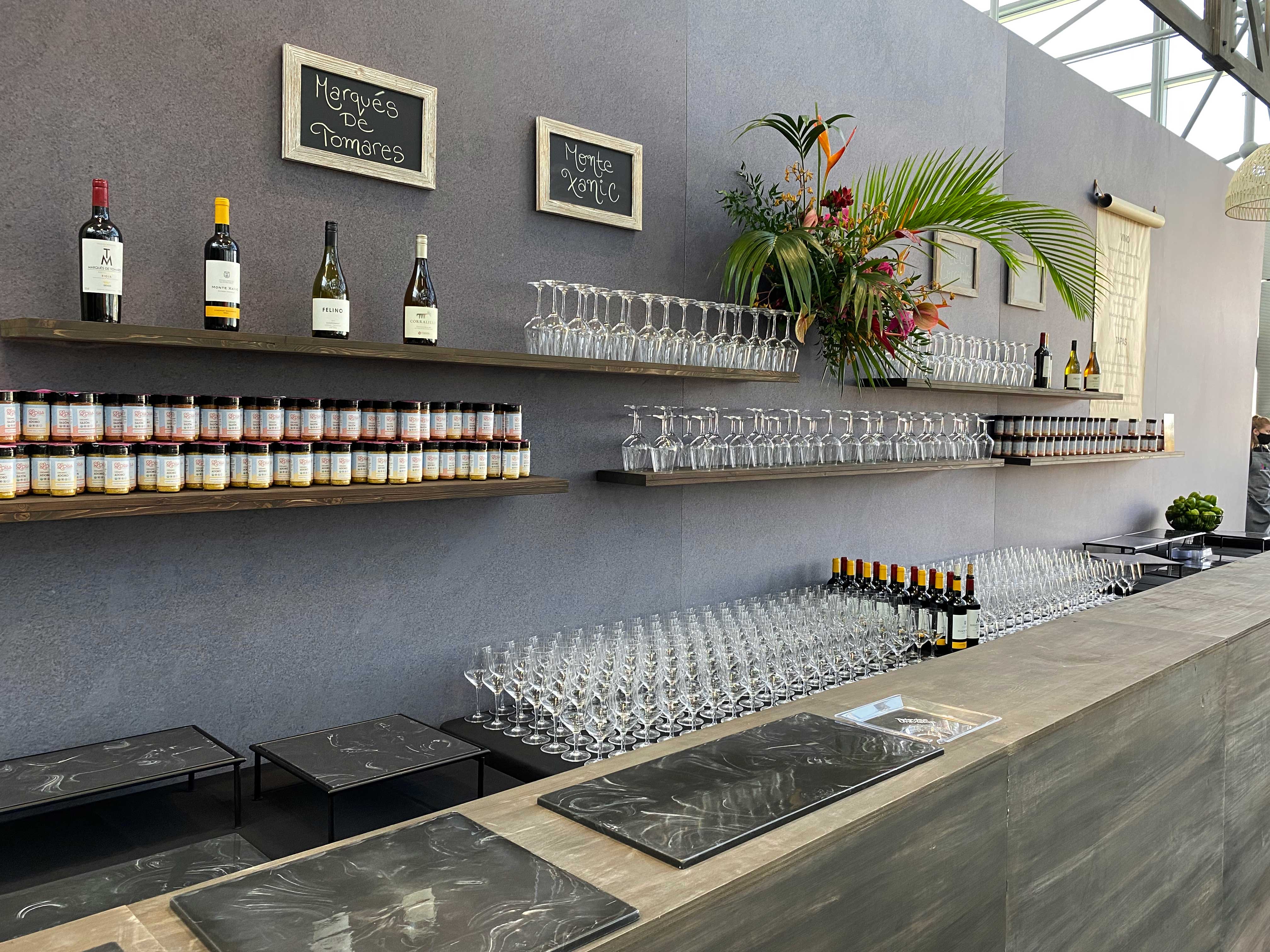 Bar with wine bottles lined on shelves and wine glasses arranged in rows on counters